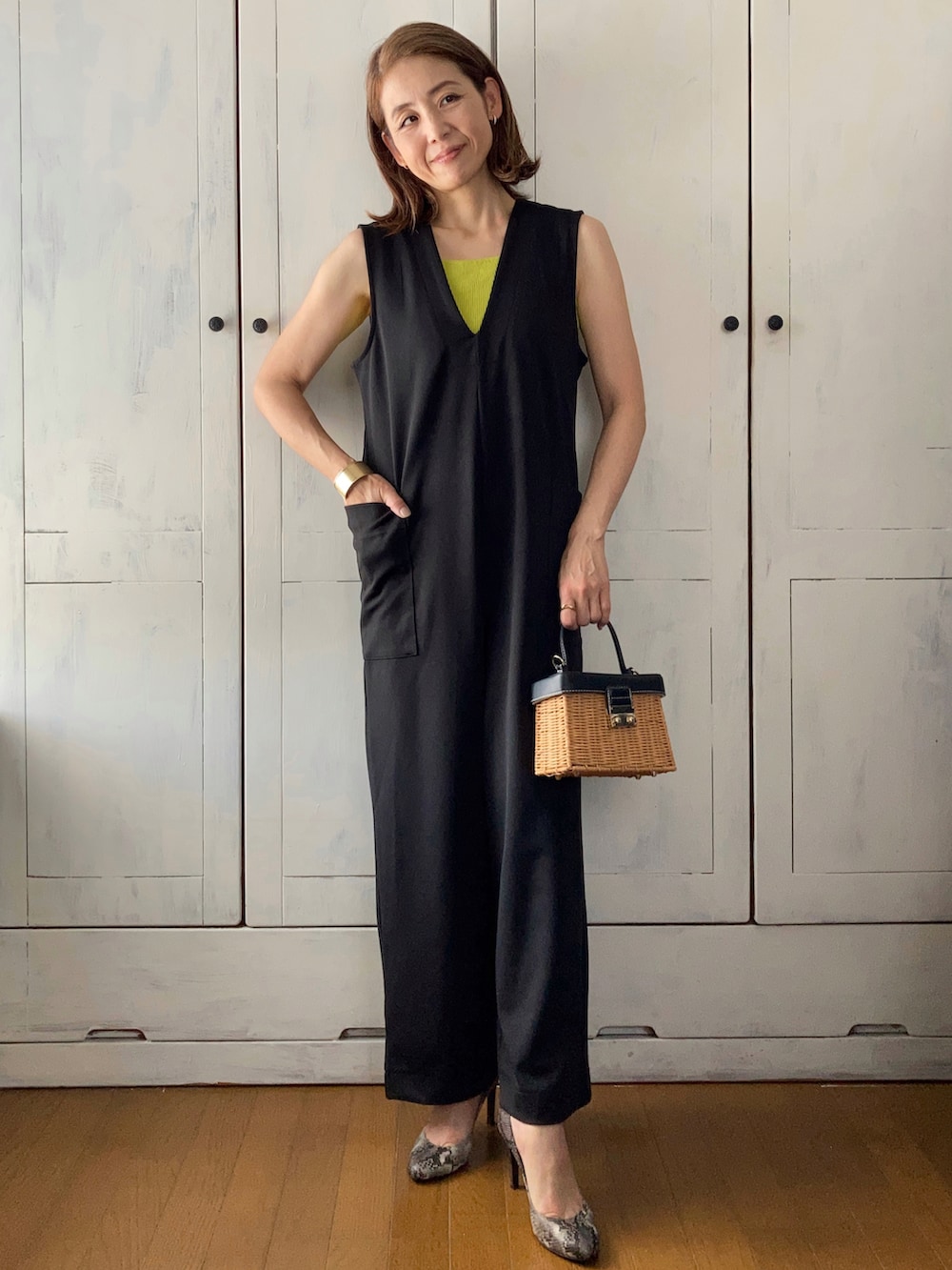 ブラック系のつなぎ/オールインワン、グリーン系のタンクトップ、ブラウン系のかごバッグを着用したレディースの春コーディネートの4枚目の写真