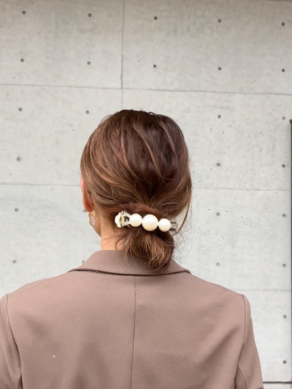 ブラウン系のスーツセット、ブラウン系のバッグ、ベージュ系のシューズを着用したレディースの冬コーディネートの3枚目の写真