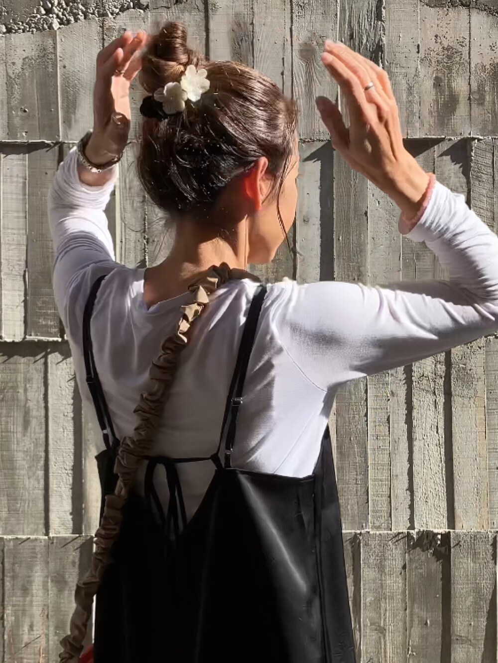 ブラック系のワンピース、オレンジ系のショルダーバッグ、ホワイト系のスニーカーを着用したレディースの冬コーディネートの2枚目の写真