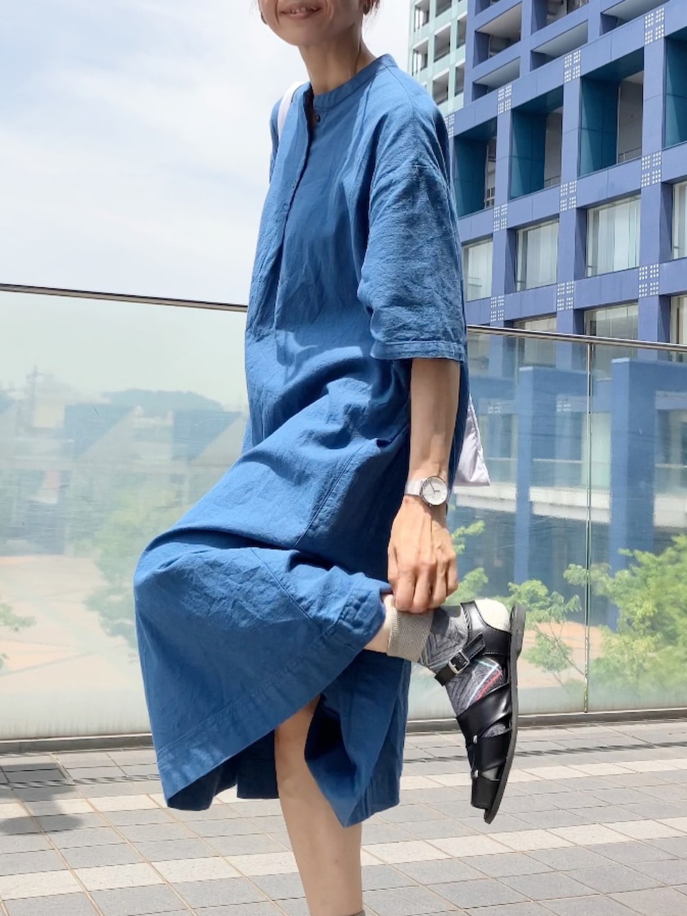 ブルー系のワンピース/ドレス、ブラック系のサンダル、レッド系のトートバッグを着用したレディースの夏コーディネートの2枚目の写真