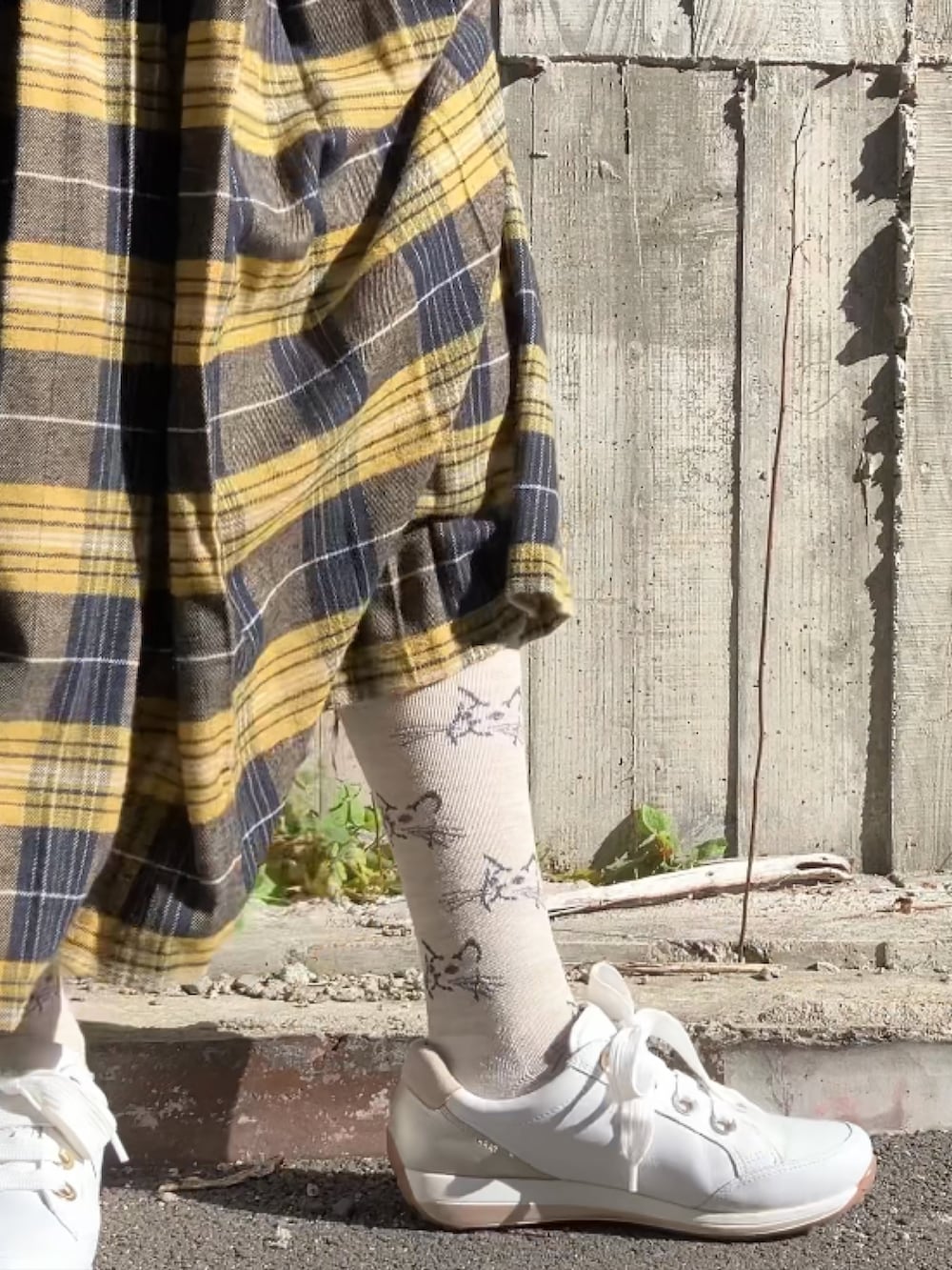 ベージュ系のボストンバッグ、ホワイト系のスニーカー、イエロー系のスカートを着用したレディースの冬コーディネートの3枚目の写真