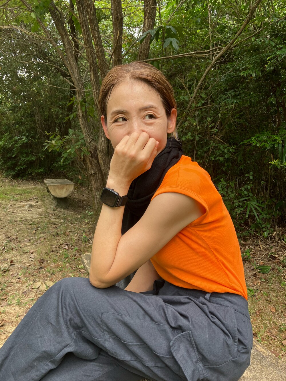 オレンジ系のTシャツ/カットソー、ブラック系のカーディガン/ボレロ、ブラック系のカーゴパンツを着用したレディースの秋コーディネートの2枚目の写真