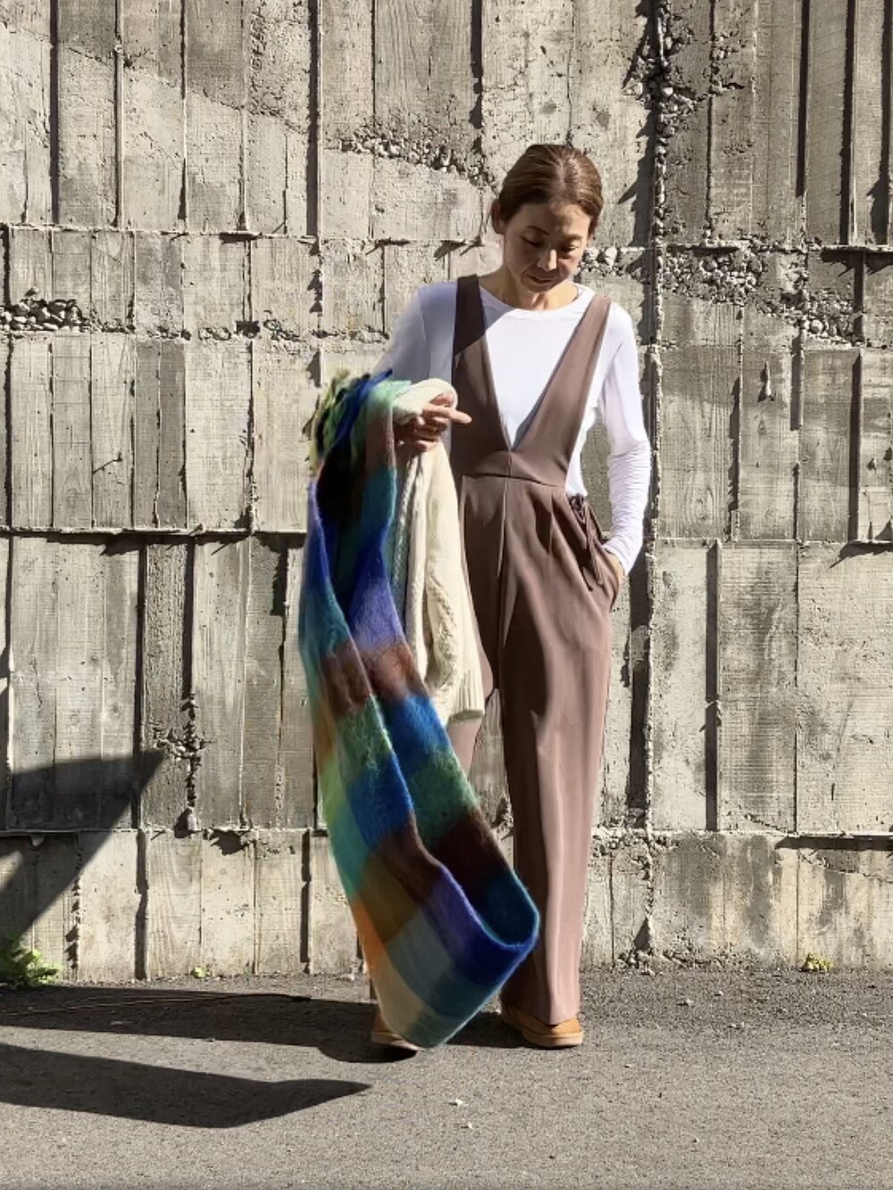 ブラウン系のサロペット/オーバーオール、ホワイト系のTシャツ/カットソー、ホワイト系のカーディガン/ボレロを着用したレディースの秋コーディネートの3枚目の写真