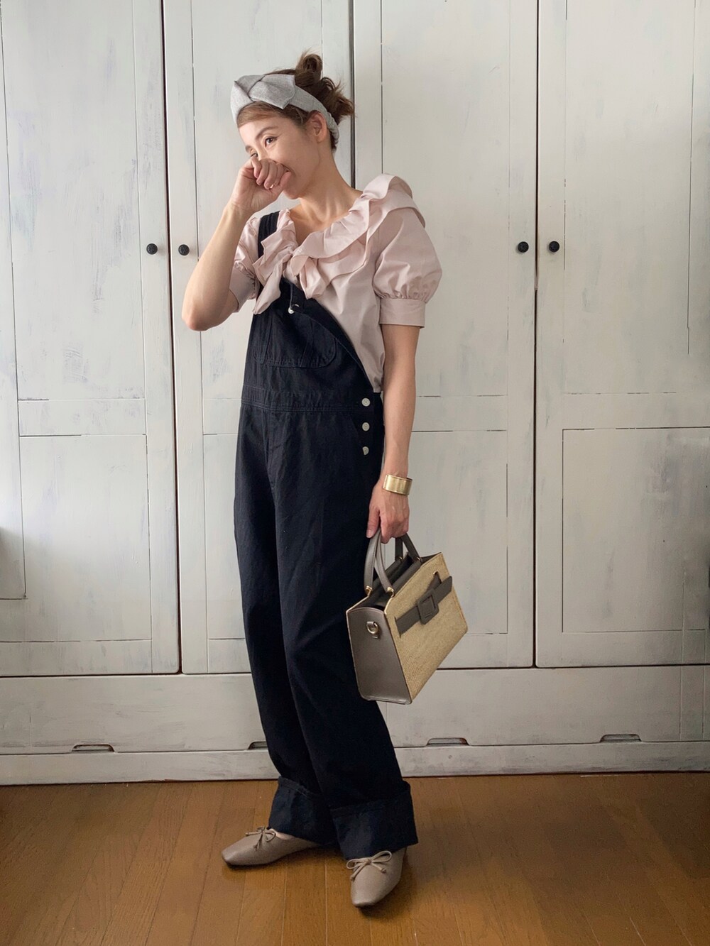 ベージュ系のシャツ/ブラウス、ブラック系のサロペット/オーバーオール、グレー系のハンドバッグを着用したレディースの春コーディネートの2枚目の写真