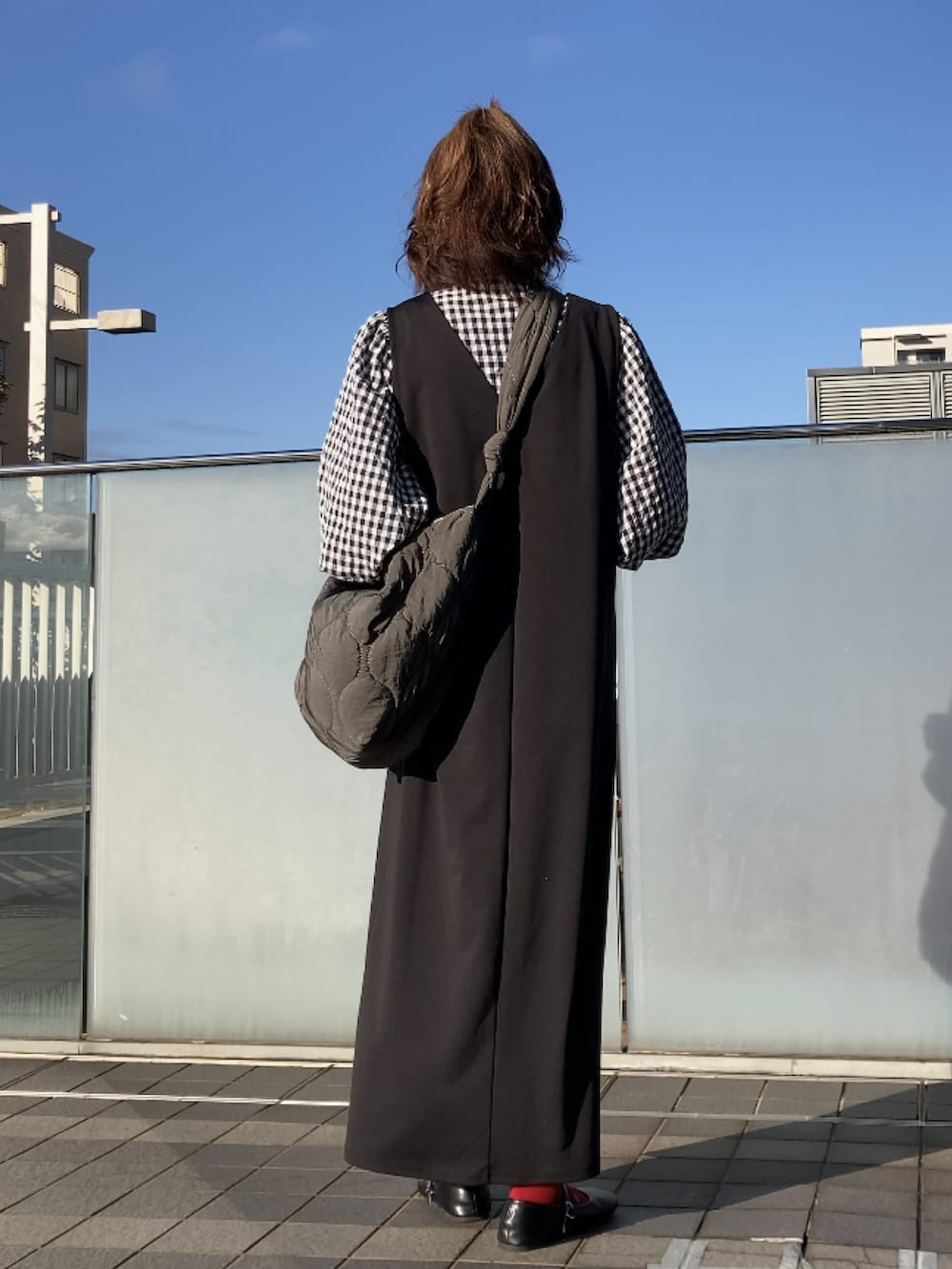 ブラック系のシャツ/ブラウス、ブラック系のジャンパースカート、グレー系のショルダーバッグを着用したレディースの秋コーディネートの4枚目の写真