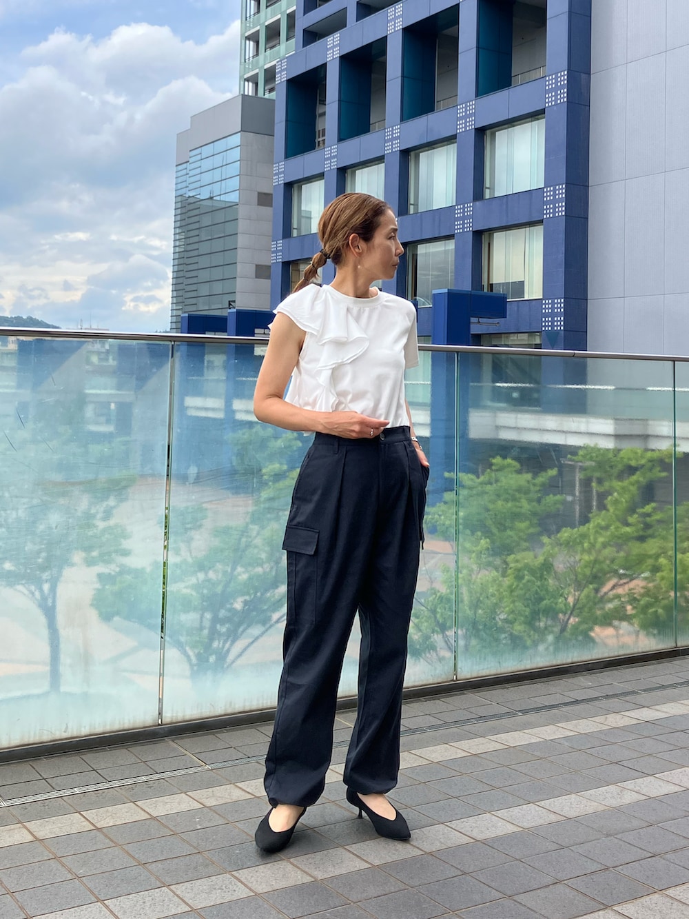 ブラック系のカーゴパンツ、ホワイト系のTシャツ/カットソー、ブラック系のパンプスを着用したレディースの夏コーディネートの2枚目の写真