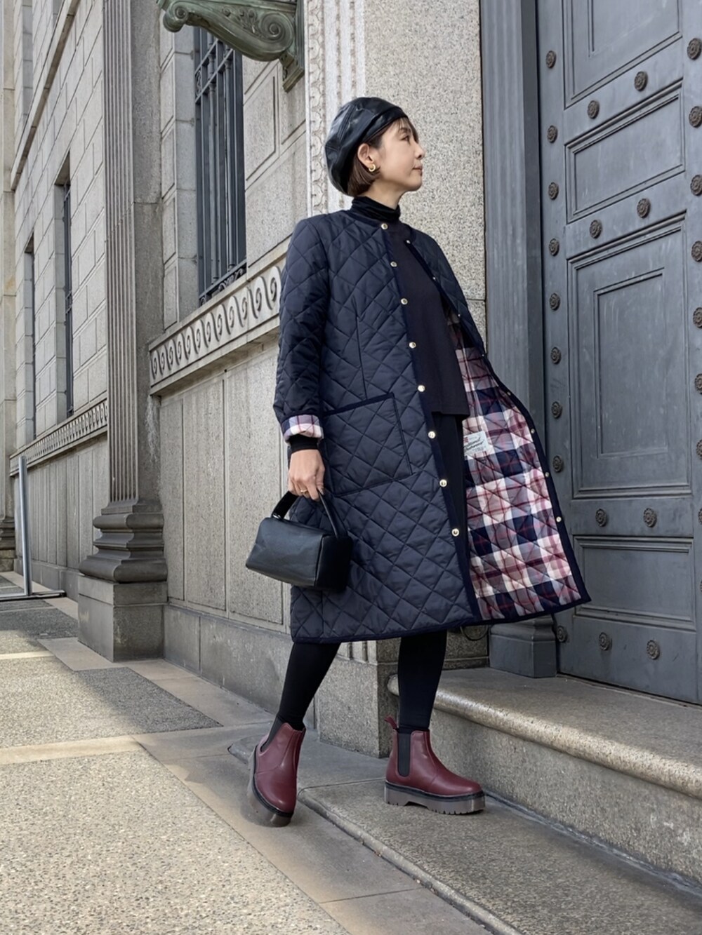 ブルー系のノーカラーコート、グレー系のワンピース、ブラック系のスーツセットを着用したレディースの秋コーディネートの3枚目の写真