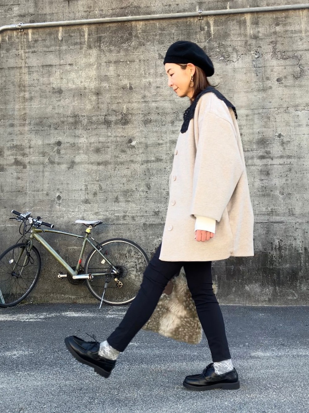 ブラック系のモカシン/デッキシューズ、ホワイト系のスウェット、ベージュ系のノーカラーコートを着用したレディースの冬コーディネートの3枚目の写真