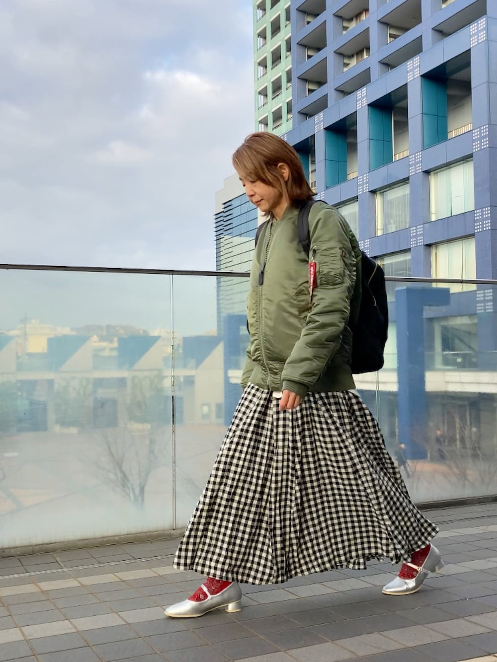 グリーン系のMA-1、ホワイト系のスウェット、グレー系のベストを着用したレディースの冬コーディネートの4枚目の写真