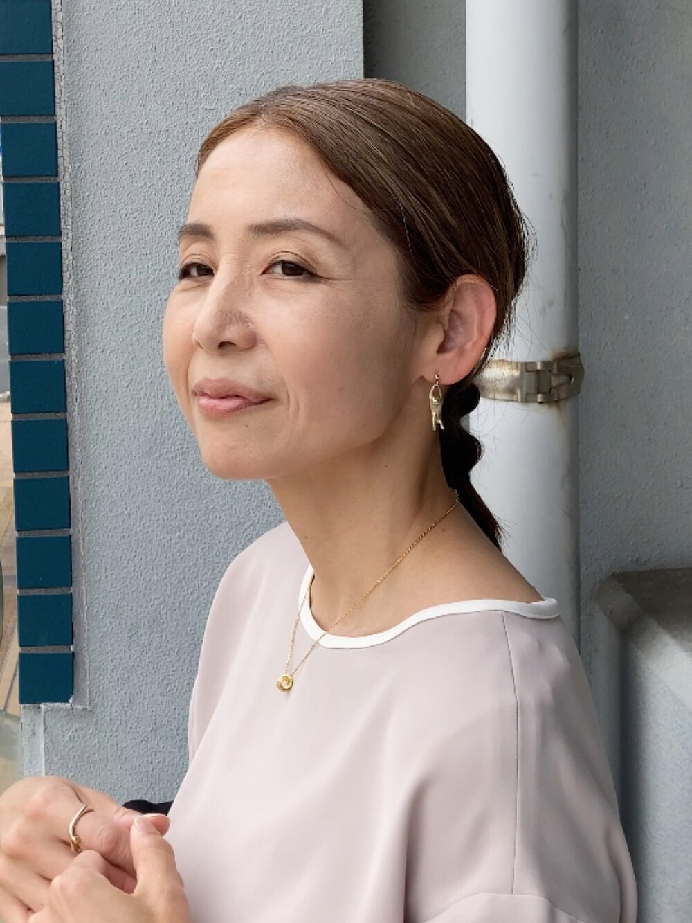 ベージュ系のワンピース、ベージュ系のビジネスバッグ、ブラック系のサンダルを着用したレディースの夏コーディネートの4枚目の写真