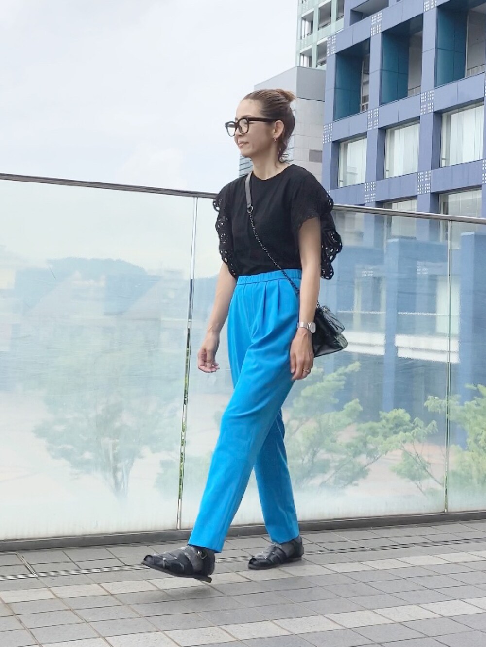 ブルー系のその他パンツ、ブラック系のTシャツ/カットソー、ブラック系のショルダーバッグを着用したレディースの夏コーディネートの5枚目の写真