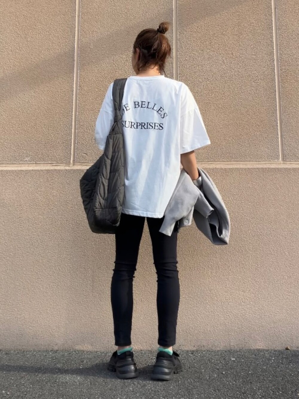 ホワイト系のTシャツ/カットソー、ブラック系のパンツ、グレー系のカーディガン/ボレロを着用したレディースの春コーディネートの2枚目の写真