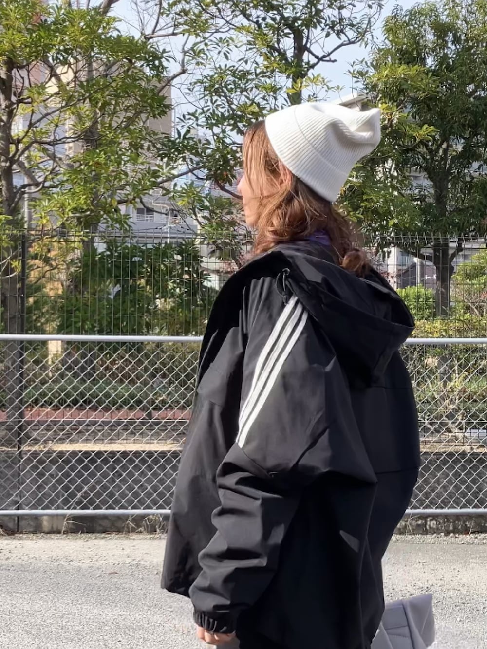 ブラック系のブルゾン、ブラック系のジャンパースカート、ブラック系のローファーを着用したレディースの冬コーディネートの4枚目の写真