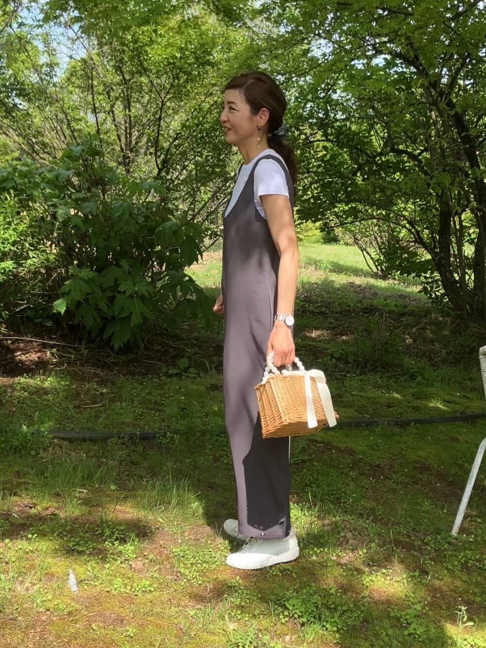 グレー系のサロペット/オーバーオール、ベージュ系のかごバッグ、ブルー系のカーディガン/ボレロを着用したレディースの春コーディネートの2枚目の写真