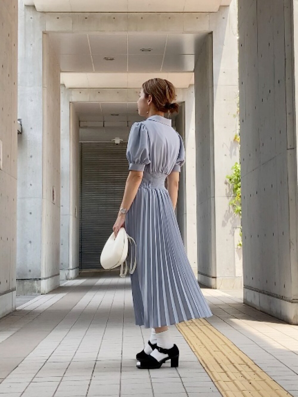 ブルー系のシャツワンピース、ブラック系のサンダル、ホワイト系のバッグを着用したレディースの夏コーディネートの3枚目の写真