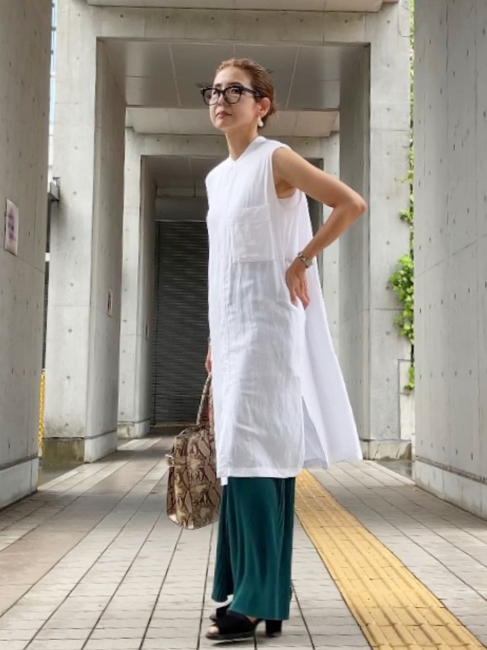 グリーン系のパンツ、ホワイト系のシャツ/ブラウス、ブラック系のカーディガン/ボレロを着用したレディースの夏コーディネートの2枚目の写真