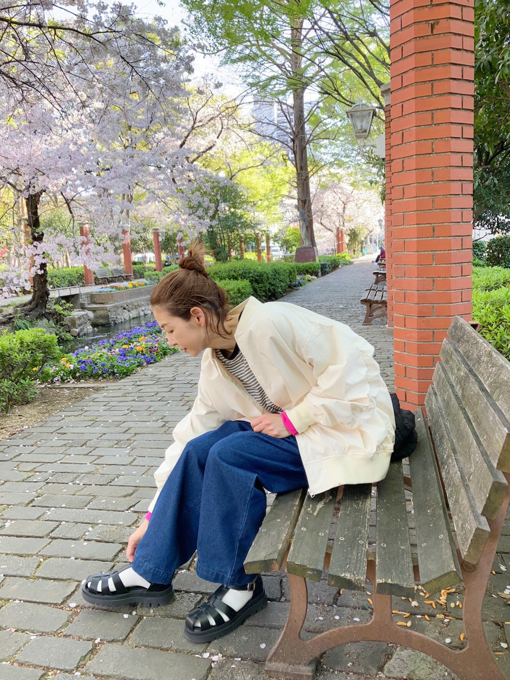 ホワイト系のMA-1、ブラック系のTシャツ/カットソー、ブルー系のデニムパンツを着用したレディースの春コーディネートの2枚目の写真