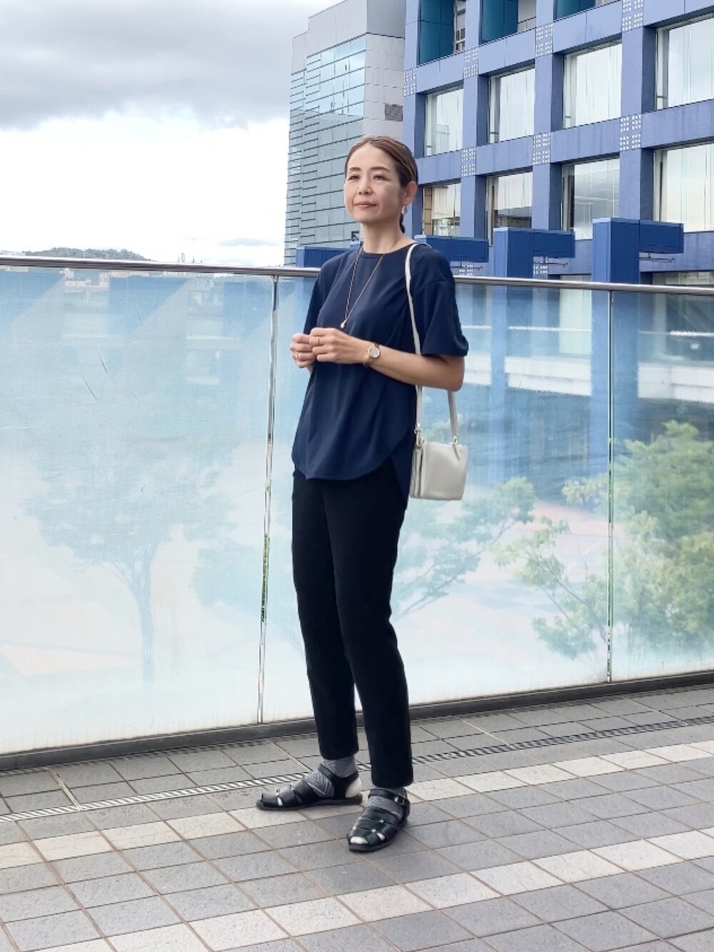 ブラック系のパンツ、ホワイト系のショルダーバッグ、ブラック系のパンツを着用したレディースの秋コーディネートの3枚目の写真