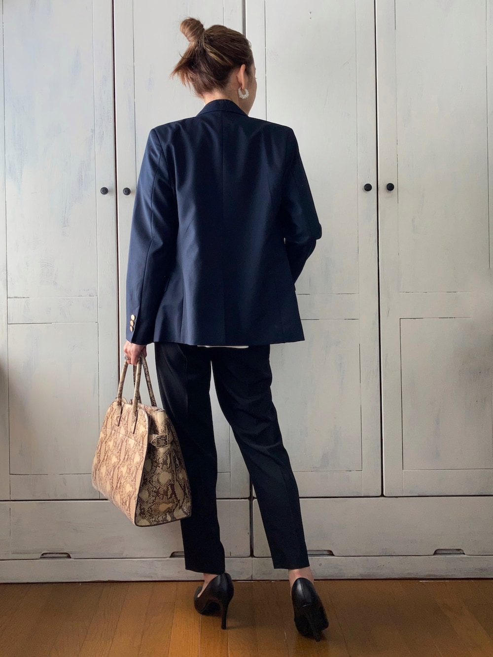 ホワイト系のスーツセット、ブルー系のテーラードジャケット、ベージュ系のバッグを着用したレディースの春コーディネートの4枚目の写真