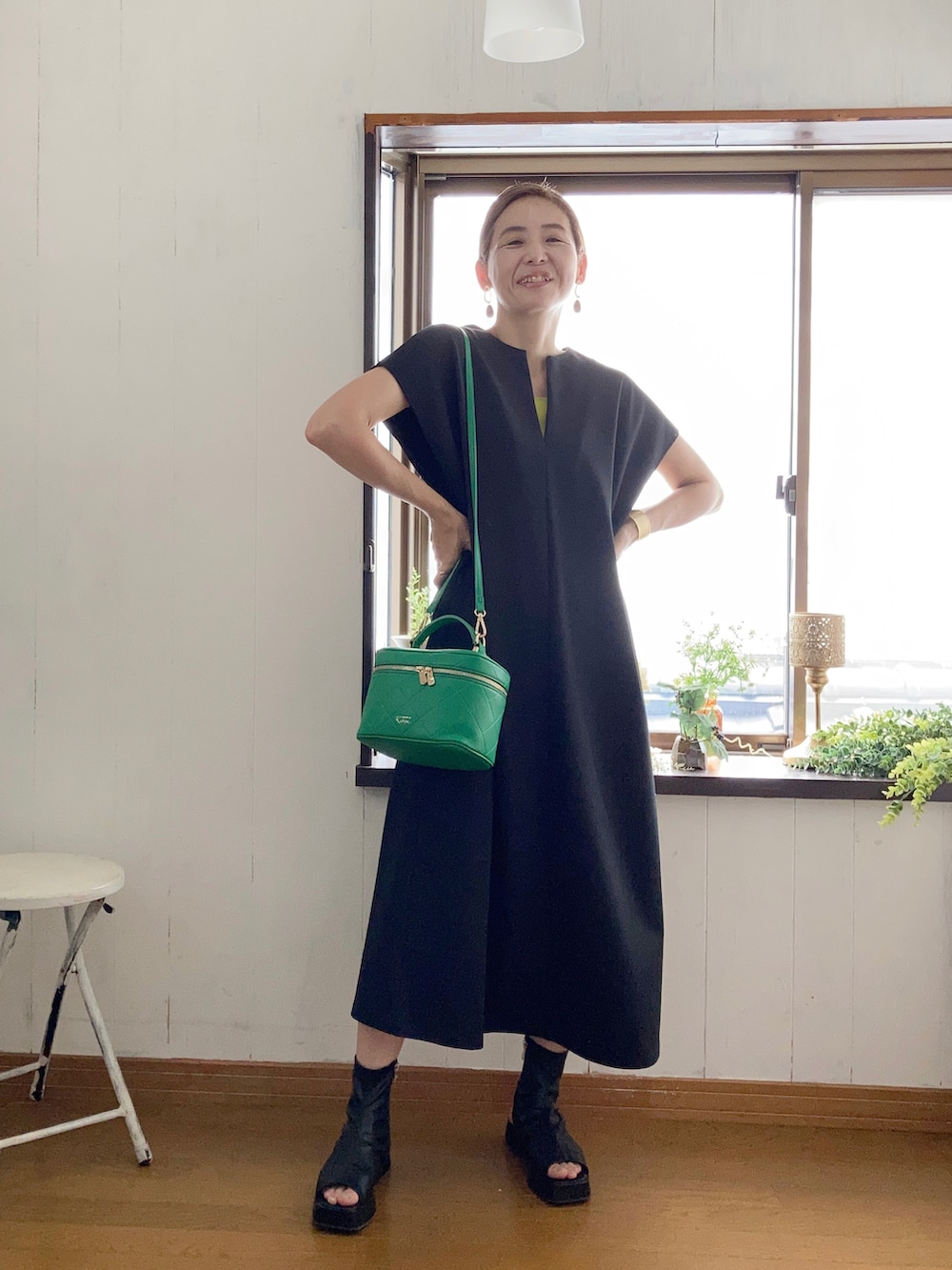 ブラック系のワンピース、グリーン系のタンクトップ、グリーン系のショルダーバッグを着用したレディースの夏コーディネートの3枚目の写真