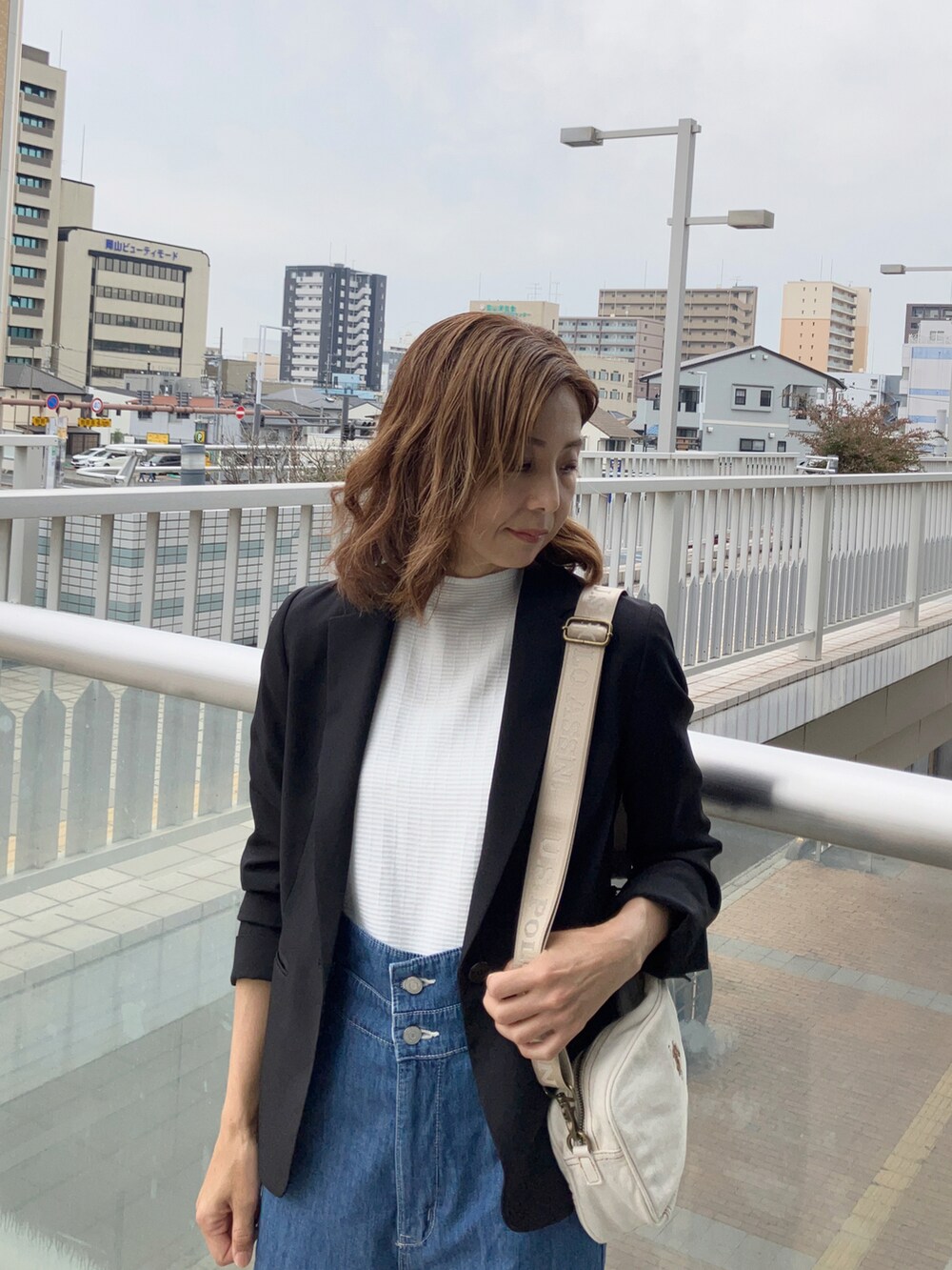 ブルー系のサロペット/オーバーオール、ホワイト系のTシャツ/カットソー、ブラック系のスーツセットを着用したレディースの夏コーディネートの2枚目の写真