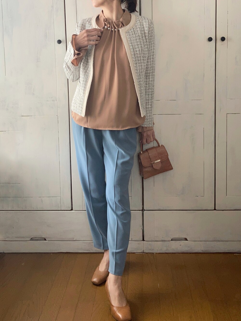 ブルー系のスーツセット、ベージュ系のシャツ/ブラウス、ベージュ系のパンプスを着用したレディースの冬コーディネートの2枚目の写真