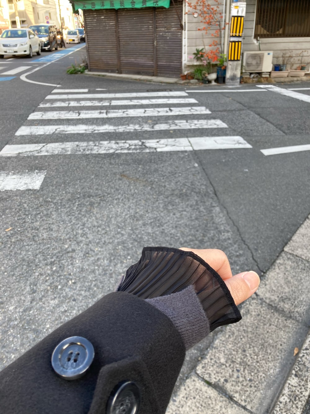 ブラック系のステンカラーコート、グレー系のニット/セーター、グレー系のショルダーバッグを着用したレディースの秋コーディネートの5枚目の写真