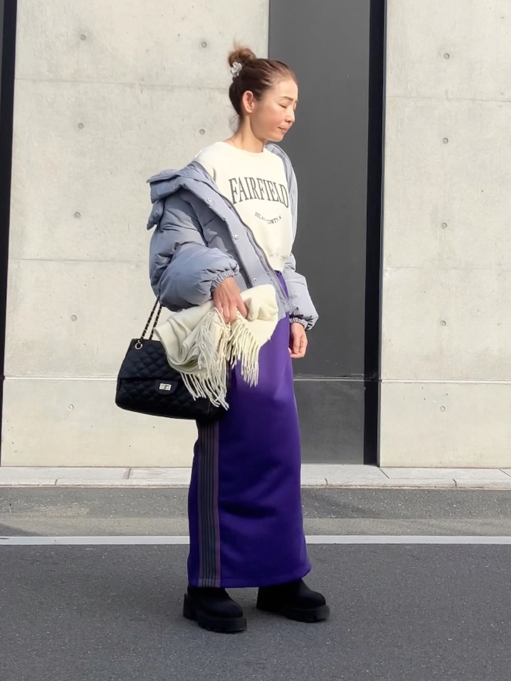 パープル系のスカート、ホワイト系のスウェット、グレー系のダウンジャケット/コートを着用したレディースの冬コーディネートの2枚目の写真