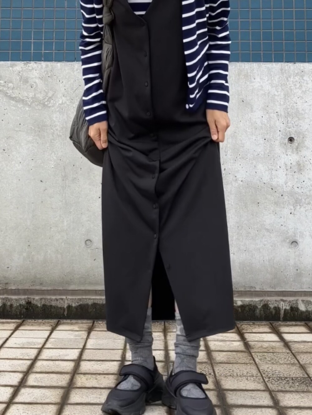 ブラック系のジャンパースカート、ブルー系のアンサンブル、ブラック系のシューズを着用したレディースの夏コーディネートの3枚目の写真