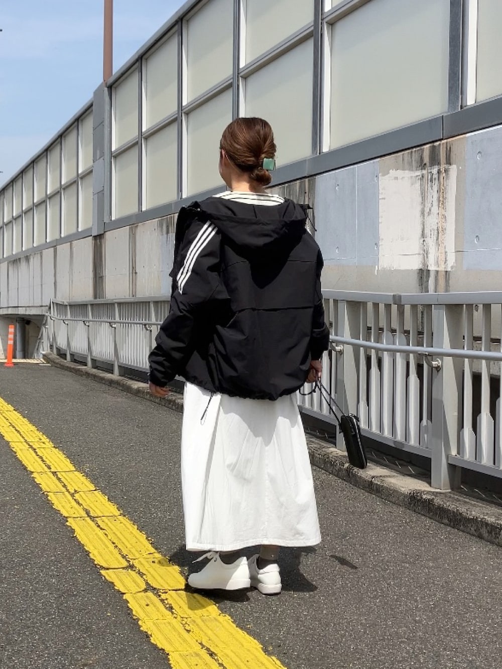 ホワイト系のワンピース、ホワイト系のスウェット、ブラック系のブルゾンを着用したレディースの春コーディネートの2枚目の写真