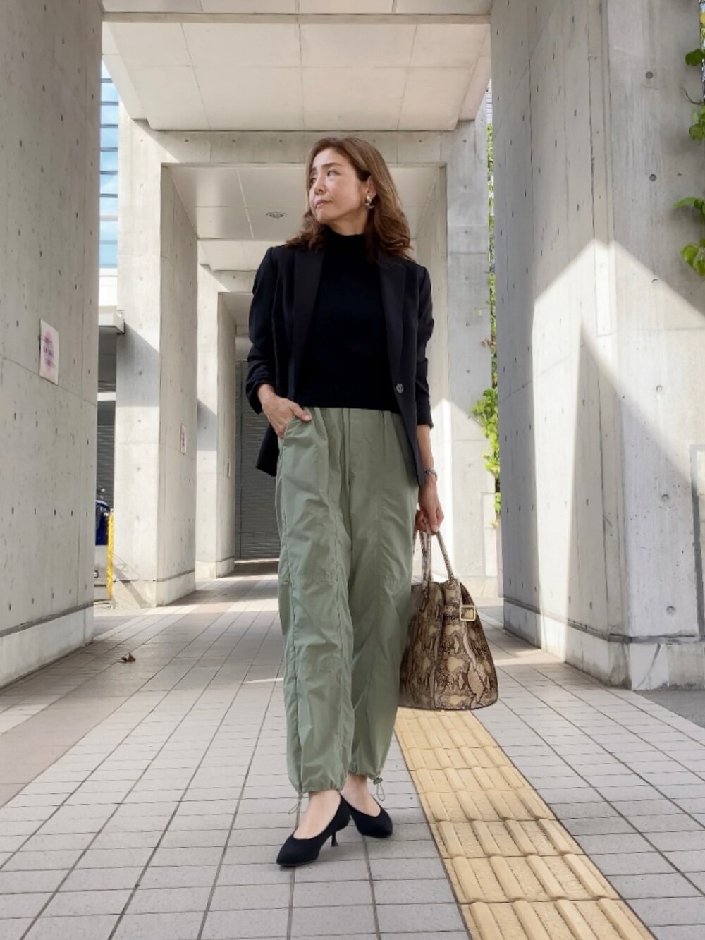 グリーン系のその他パンツ、ブラック系のスーツセット、その他のバッグを着用したレディースの秋コーディネートの2枚目の写真