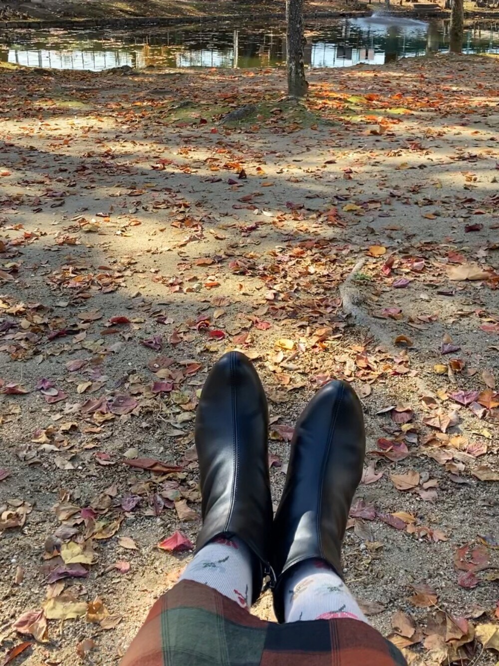 ブラウン系のチェスターコート、ブラック系のブーツ、ホワイト系のスウェットを着用したレディースの秋コーディネートの4枚目の写真