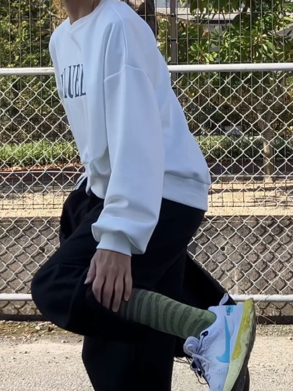 ホワイト系のスウェット、ブラック系のスウェットパンツ、ブラック系のブルゾンを着用したレディースの冬コーディネートの4枚目の写真