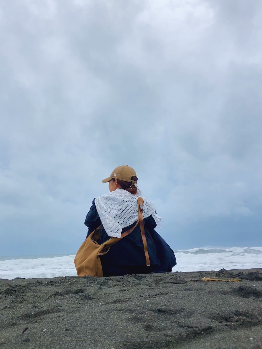 ブラック系のトップス、ベージュ系のショルダーバッグ、ブラック系のパンツを着用したレディースの夏コーディネートの5枚目の写真