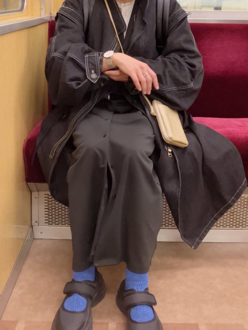 ブラック系のモッズコート、ブラック系のカーディガン/ボレロ、ホワイト系のシャツ/ブラウスを着用したレディースの春コーディネートの5枚目の写真