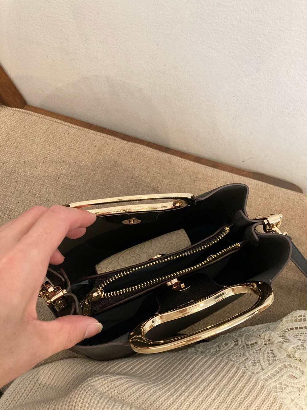 ブラック系のハンドバッグ、ホワイト系のスカート、ホワイト系のベストを着用したレディースの春コーディネートの5枚目の写真