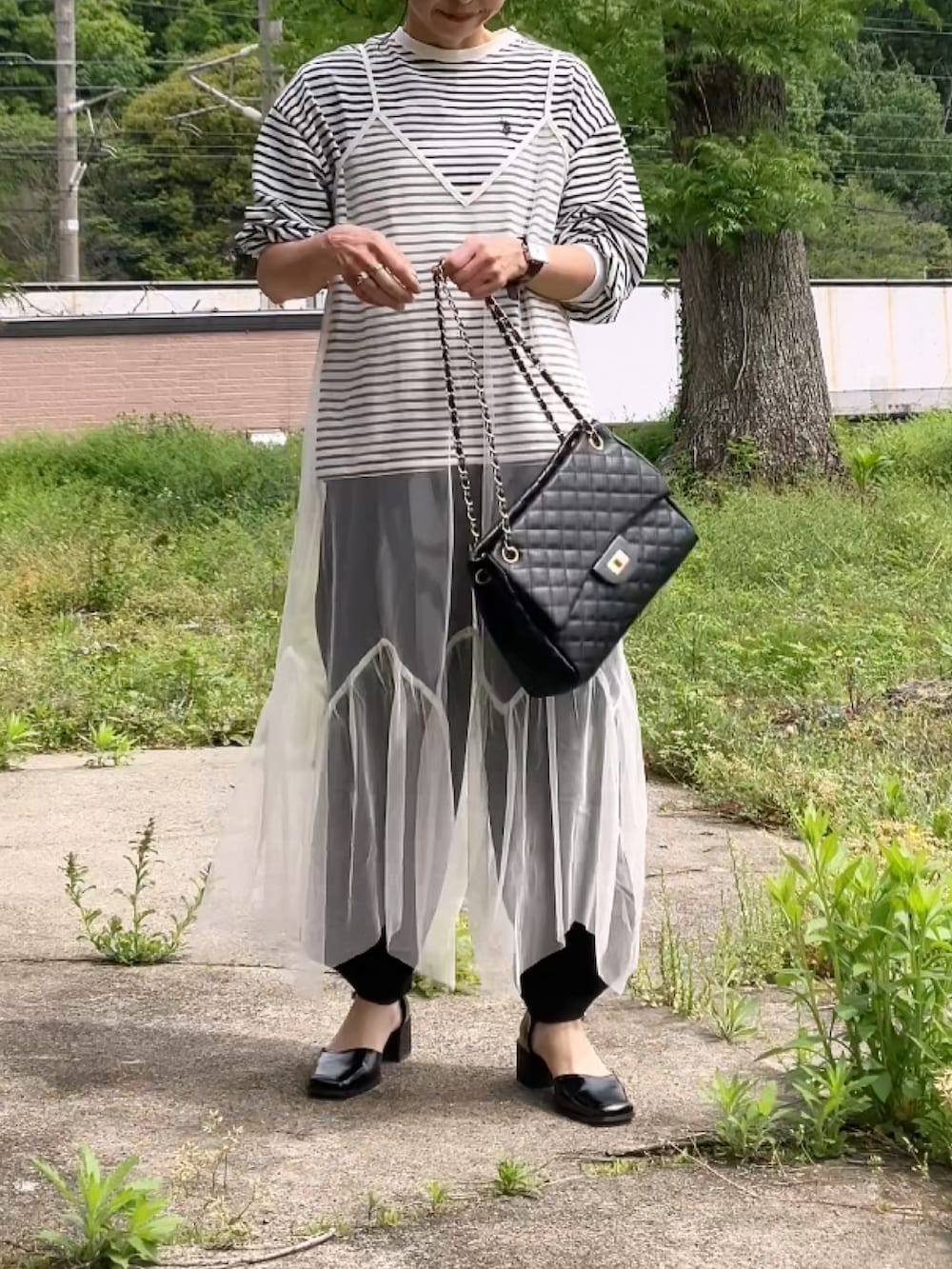 ホワイト系のワンピース、ブラック系のスウェットパンツ、ブラック系のTシャツ/カットソーを着用したレディースの春コーディネートの2枚目の写真