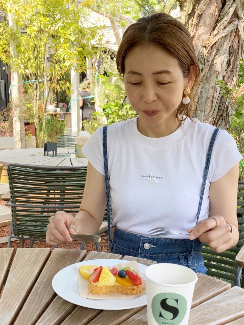 ホワイト系のTシャツ/カットソー、ブルー系のサロペット/オーバーオール、ブラウン系のバックパック/リュックを着用したレディースの春コーディネートの2枚目の写真