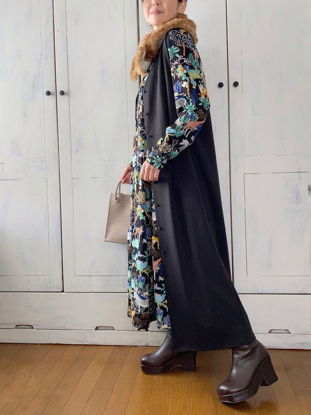 ブラック系のワンピース、ブラック系のジャンパースカート、ブラウン系のブーツを着用したレディースの冬コーディネートの2枚目の写真