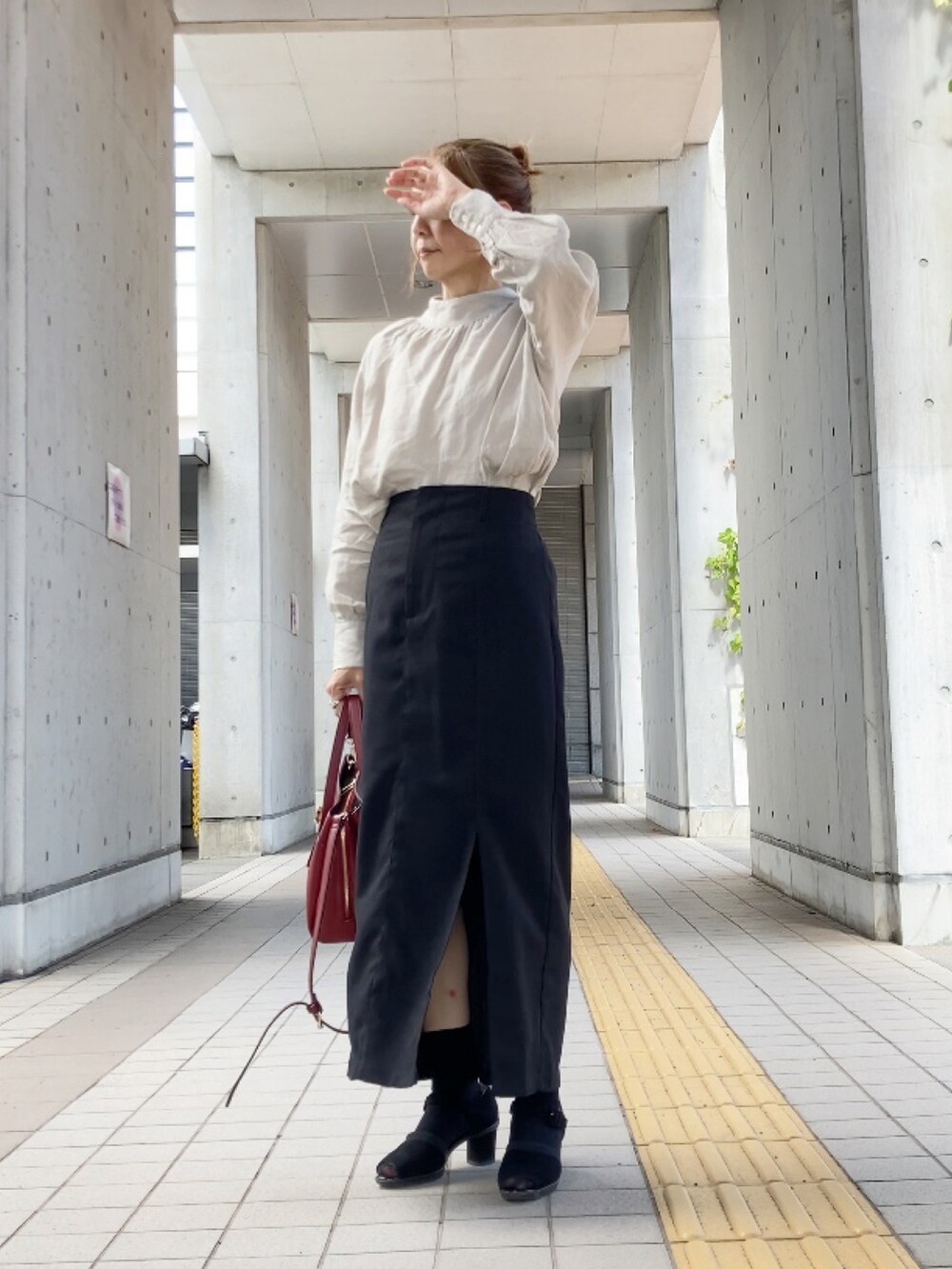 ベージュ系のシャツ/ブラウス、ブラック系のスカート、レッド系のハンドバッグを着用したレディースの秋コーディネートの3枚目の写真