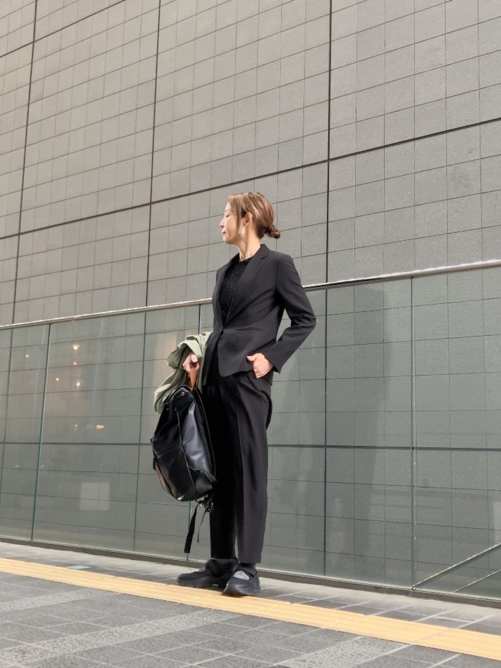 ブラック系のスーツセット、ブラック系のシャツ/ブラウス、ブラック系のシューズを着用したレディースの春コーディネートの2枚目の写真