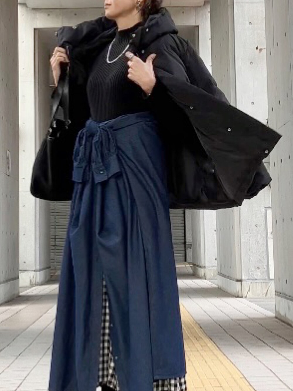 ブラック系のダウンジャケット/コート、ブラック系のトートバッグ、ブラック系のニット/セーターを着用したレディースの冬コーディネートの2枚目の写真