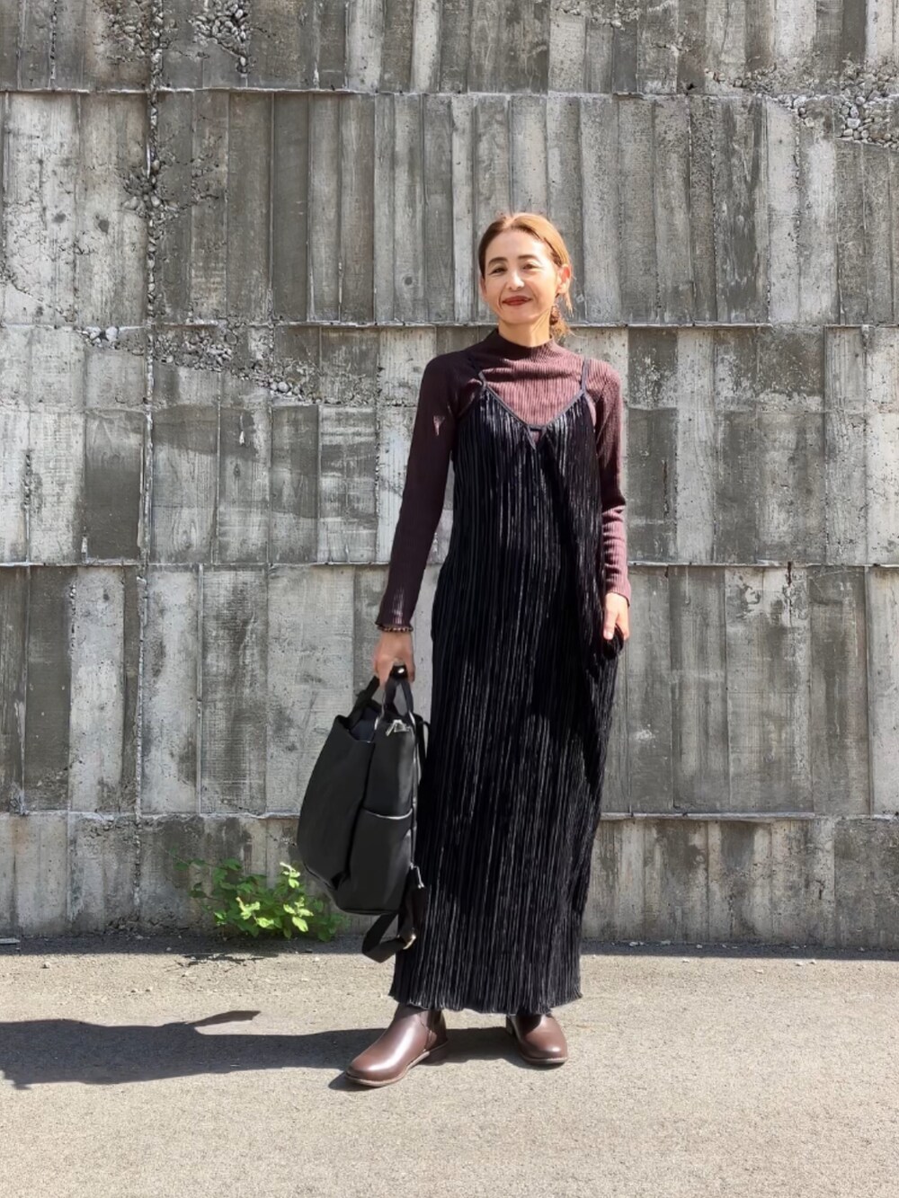 ブラック系のワンピース、ブラック系のバックパック/リュックを着用したレディースの秋コーディネートの3枚目の写真