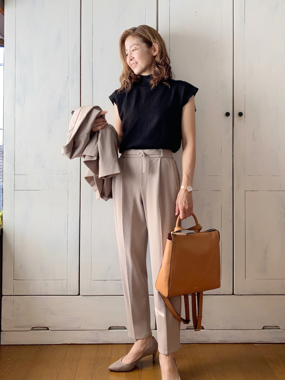 ベージュ系のスーツセット、イエロー系のバックパック/リュック、ブラック系のニット/セーターを着用したレディースの秋コーディネートの4枚目の写真