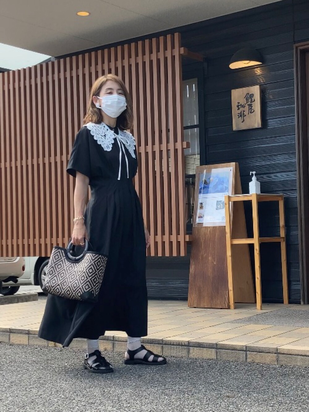 ブラック系のワンピース、ブラック系のかごバッグ、ブラック系のサンダルを着用したレディースの夏コーディネートの2枚目の写真