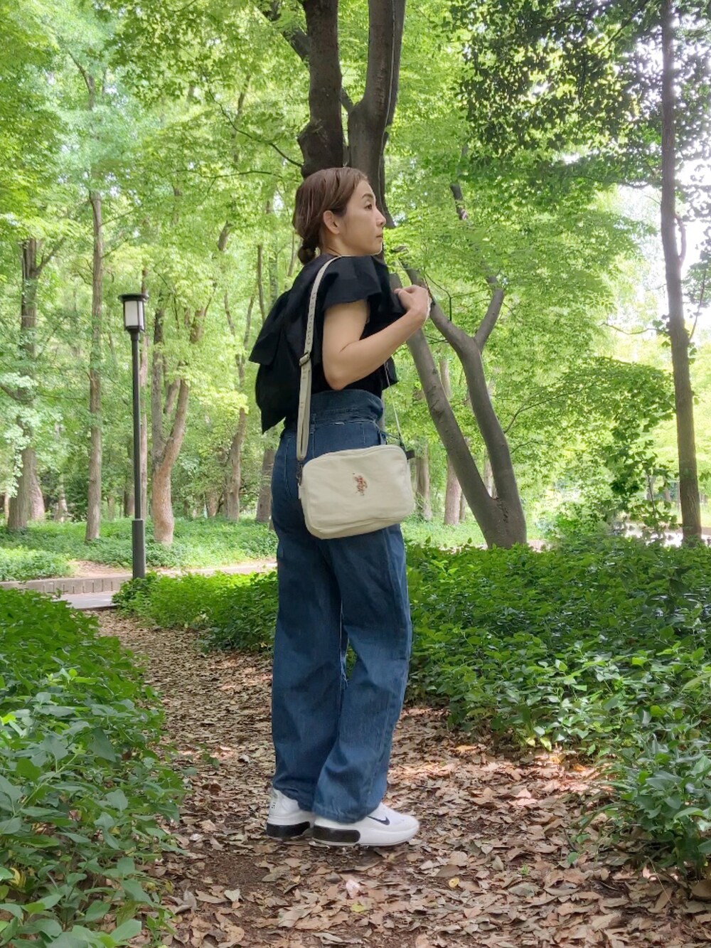 ブラック系のシャツ/ブラウス、ブルー系のサロペット/オーバーオール、ホワイト系のショルダーバッグを着用したレディースの春コーディネートの3枚目の写真