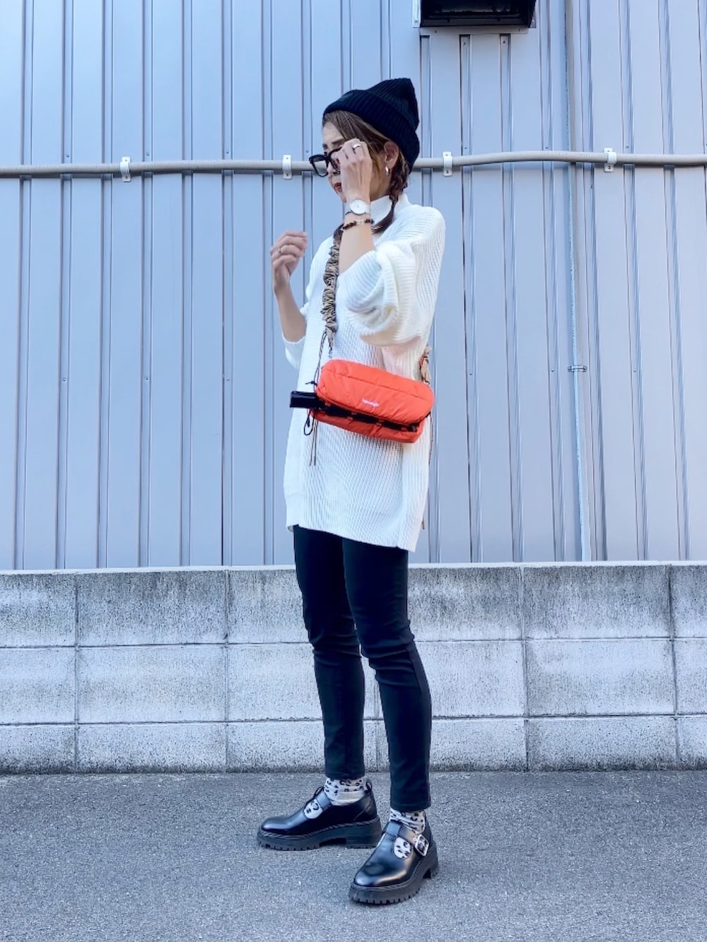 ホワイト系のニット/セーター、オレンジ系のショルダーバッグ、ブラック系のシューズを着用したレディースの秋コーディネートの2枚目の写真