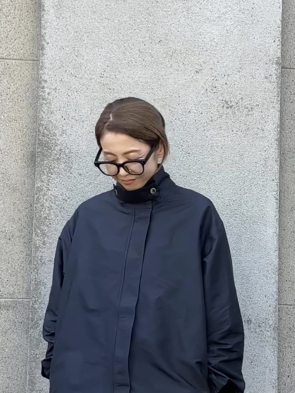 ブラック系のシューズ、ブラック系のステンカラーコート、ホワイト系のエコバッグ/サブバッグを着用したレディースの秋コーディネートの2枚目の写真