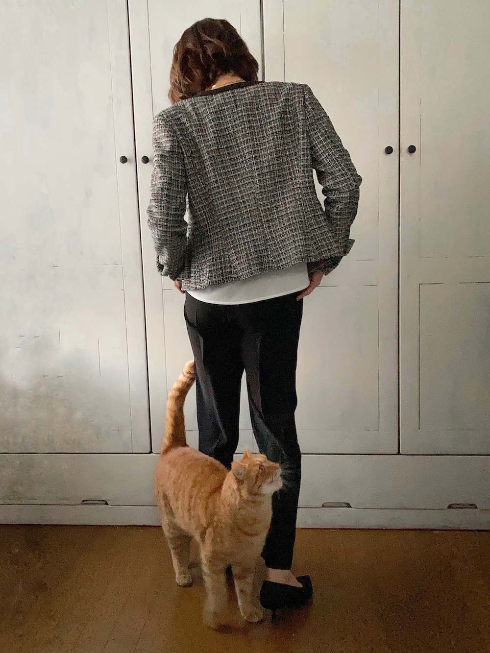 ブラック系のスーツセット、ブラック系のハンドバッグ、ブラック系のパンプスを着用したレディースの冬コーディネートの3枚目の写真