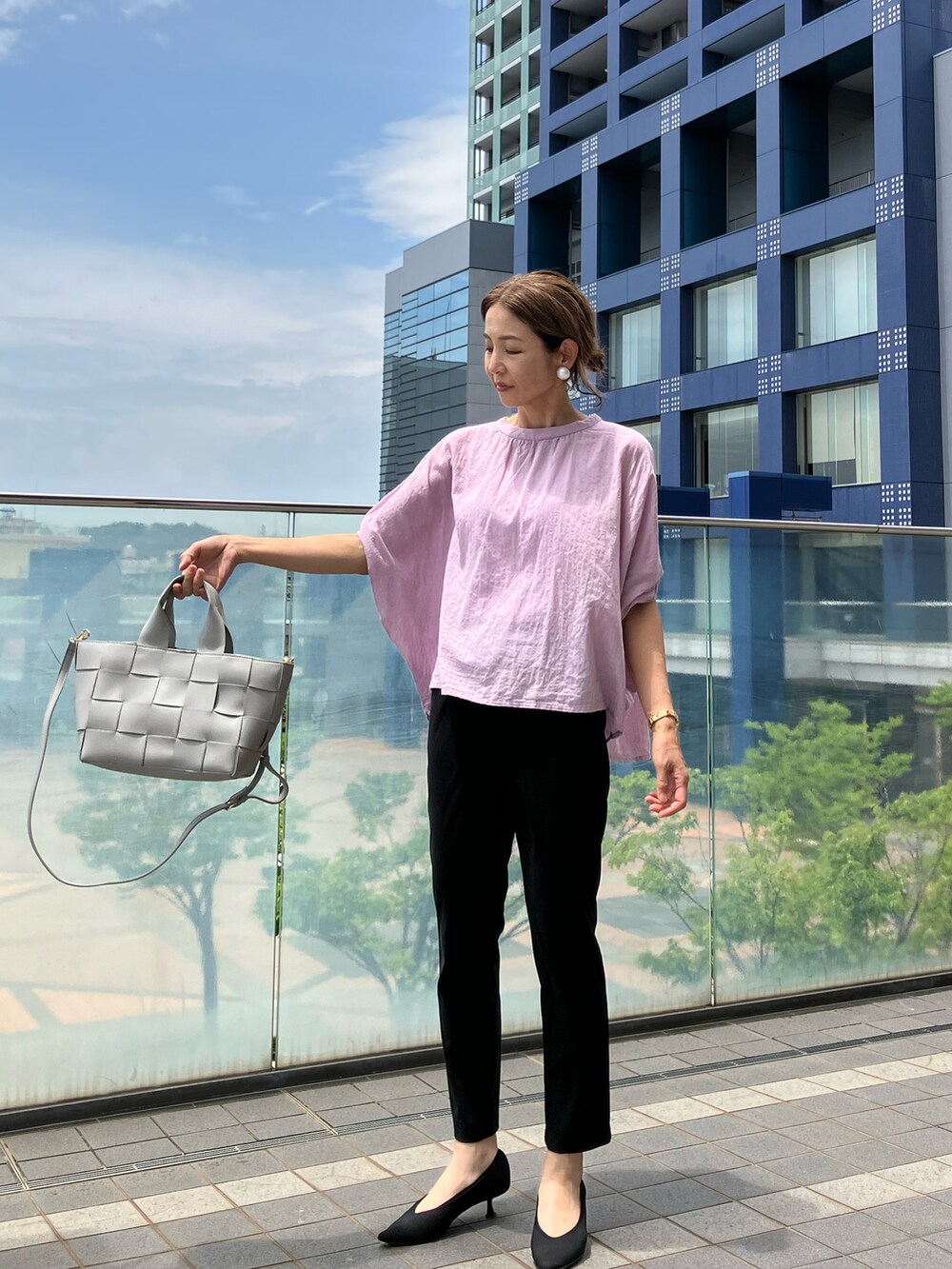 グレー系のハンドバッグ、パープル系のシャツ/ブラウス、ブラック系のパンツを着用したレディースの夏コーディネートの4枚目の写真